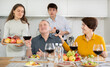 © JackF - Father and mother together with adult children talking at the dinner table at home