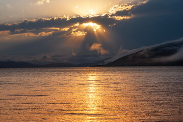 Wall Mural - Beautiful sunset with clouds over the lake.