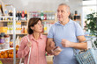 © JackF - Couple of elderly man and woman with dried meat and basket of food choosing groceries in store
