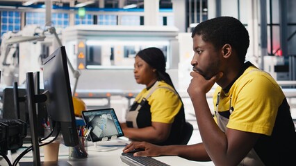 Poster - black engineer works on solar software settings in automated factory, optimizing the production proc