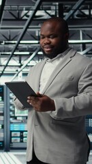 Poster - Vertical video Cheerful data center programmer looking at code debugging tools running on tablet. Server farm IT professional typing on device touchscreen, writing script automating tasks, camera A