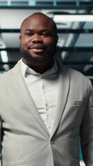 Poster - Vertical video Smiling manager in data center doing checkup on hardware to avoid downtime. Happy african american supervisor overseeing server room infrastructure supercomputers, camera B