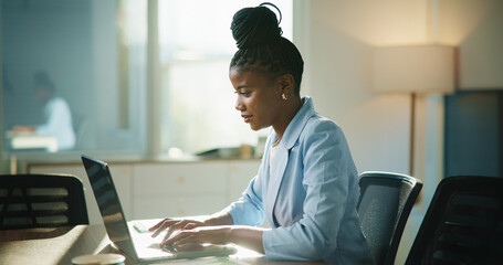 Poster - Business, laptop and black woman in office, typing and email for payroll schedule. African person, accountant and employee in workplace, pc or budget report with financial website or funding proposal