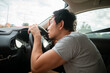 © Suthida - Asian man peering intensely through windshield, bad traffic car accident