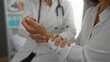 © Krakenimages.com - Woman doctor examining wrist of patient in clinic, highlighting healthcare interaction in a professional medical setting with focus on empathy and care.