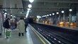 People waiting on an out of focus london tube platform with blurred figures and bokeh lights creating a dreamy underground atmosphere on a busy day.