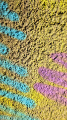 Poster - Vibrant spray paint splattering blue, yellow, purple hues across weathered concrete wall, representing urban graffiti artistic expression