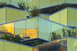 © yaqui_villegas - Reflective glass facade with modular green terraces and integrated plants, Montpellier, France, sustainable architecture concept with urban garden innovation
