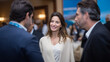 © Debi Kurnia Putra - Professional businesswoman networking at corporate event with male colleagues