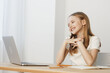 © SHOTPRIME STUDIO - Young smiling girl interacting with a laptop, showcasing joy and enthusiasm, in a bright, minimalistic home office setting, emphasizing modern technology and learning
