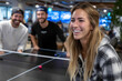 © YouraPechkin - Friends enjoying table tennis in a lively indoor space during evening hours