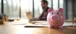 © Kazakov - The cheerful piggy bank representing savings and financial planning in a modern workspace.