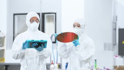 Poster - 半導体工場でタブレットを持ってシリコンウエハーを検査する防護服を着た男女作業員