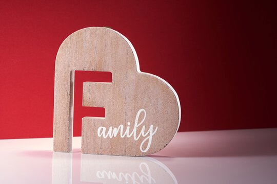 wood material heart shape with word family against red background