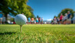 © sornram - A close-up of a golf ball on a tee, with blurred spectators in the background enjoying a sunny day on the course.