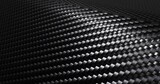 Carbon fiber textured material placed on a curved path with light shining from one side 