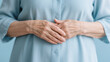 © Murshidi Mahmud Ful - close-up of elderly hands expressing serenity in light blue clothing, the light blue shirt suggests gentleness, care, and peacefulness. old woman's hand, 60 years old, senior nurse's hand
