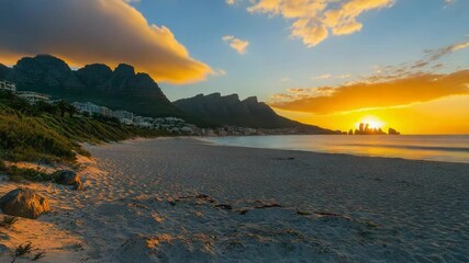 Wall Mural - beautifully lit landscape with a sunset over the beach and surrounding mountains