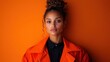 © svastix - A striking portrait of a young woman with curly hair, set against a vibrant orange background, capturing beauty and confidence in a modern aesthetic.