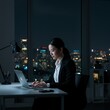 © Wangwit - Determined Young Woman Working Late in Modern Office