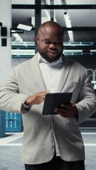 Poster - vertical video smiling admin using tablet in in data center maintaining infrastructure for workloads