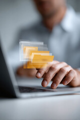 Poster - Man working on laptop, interacting with floating digital folders. Data management, cloud computing, and information technology concept. Great for business, finance.