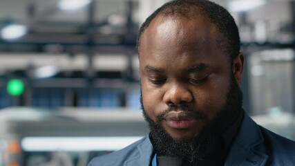 Poster - african american male engineer reviewing the production line activity at the facility, examining sol