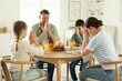 © New Africa - Family praying together before dinner at table indoors