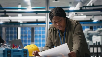 Poster - african american technician reading documents in the manufacturing plant, inspecting solar panels eq