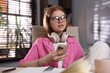 © New Africa - Teenage student with headphones using smartphone while studying at home