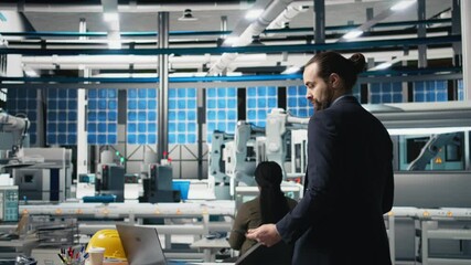 Poster - professional engineer managing the production line for solar panels, examining equipment and efficie