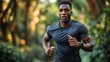 © rak - a focused african american male athlete jogging through a lush green forest path with determination and athletic prowess showcasing health and fitness for a vibrant active lifestyle