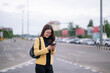© Wasana - Young businesswoman using smartphone on city street