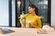 © David - Portrait of Creative young asian woman holding coffee cup and  thinking and working on tablet laptop at coffee shop.Freelance education and technology concept.