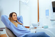 © nicoletaionescu - Happy Patient Sitting Relaxed in the Dental Office. Smiling woman takes preventive care of her oral health