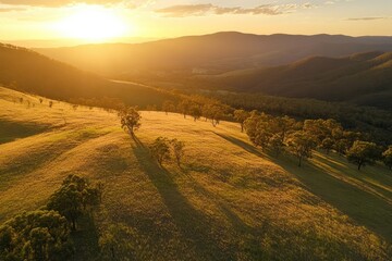 Poster - Sunset glow illuminates grassy mountain slopes and casts long shadows across serene landscape, Sunset glow on grassy mountain side - beautiful drone shot