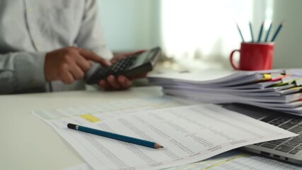 Poster - businessman uses a calculator and paperwork to analysis finances, investments, and tax reports at his desk calculator and digital tablet. business financial reports and data analysis