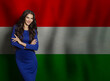 © millaf (Nemchinova) - Happy young woman in blue dress smiling against Hungarian flag background