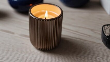 Poster - Candle flame ribbed brown minimalist decor serene wood table, cozy warm home ambiance for relaxation and peaceful wax light