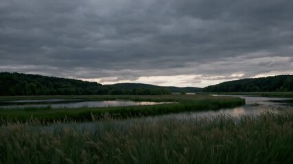 Aufkleber - Tranquil river scene with cloudy sky, lush green grass, calm water, peaceful landscape, serene nature view, outdoor natural