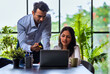 © StockImageFactory - Indian businessmen Working on laptop and reviewing project papers together at desk in indoor office