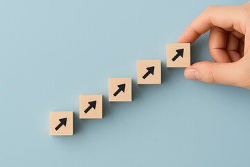 Poster - Progress and growth are represented by wooden cubes arranged diagonally with upward arrows symbolizing strategic advancement and success