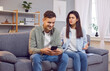 © Studio Romantic - Couple having phone addiction problem. Man looking at cellphone ignoring woman. She feels jealous and irritated while he has fun watching video, playing leisure game, cheating in dating flirting app