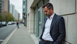 © AlenaKo - Upset man in business suit leaning against wall on city sidewalk