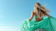 © svastix - A stunning shot of a woman in a flowing green dress, twirling joyfully against a bright blue sky, symbolizing freedom, elegance, and the beauty of nature.