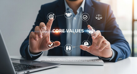 Poster - Man presenting core values icons with laptop and keyboard on a white desk in an office setting