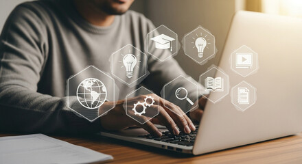 Aufkleber - Person typing on a laptop with educational icons floating around the screen in a bright setting