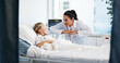© peopleimages.com - Healthcare, doctor and kid in bed for recovery, treatment update and teddy bear for comfort. Girl patient, pediatrician and smile in hospital for successful surgery, medical support and plushie