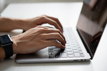 Poster - Close up of hands typing on a silver laptop keyboard