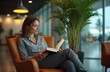 © Maryna - Businesswoman relaxes airport lounge reading book. Female traveler rests in comfortable armchair, enjoys reading during travel. Elegant woman in business trip, leisure lifestyle. Comfort,